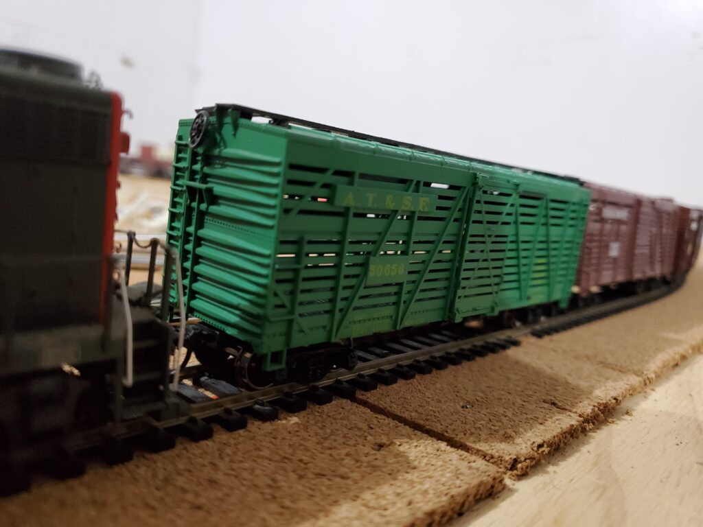 Model train with green freight car.